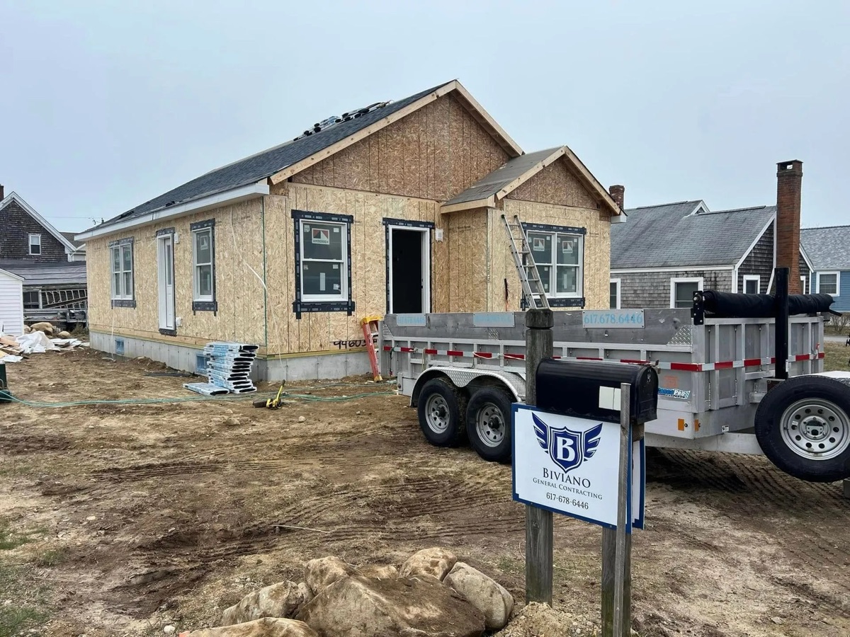 Marshfield modular spec home during construction — OSB sheathing exposed, Biviano sign in foreground