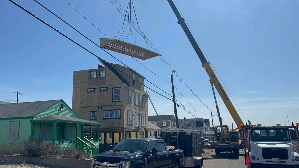 Biviano Modular Builders crane setting a custom modular home on coastal pilings in Humarock, MA